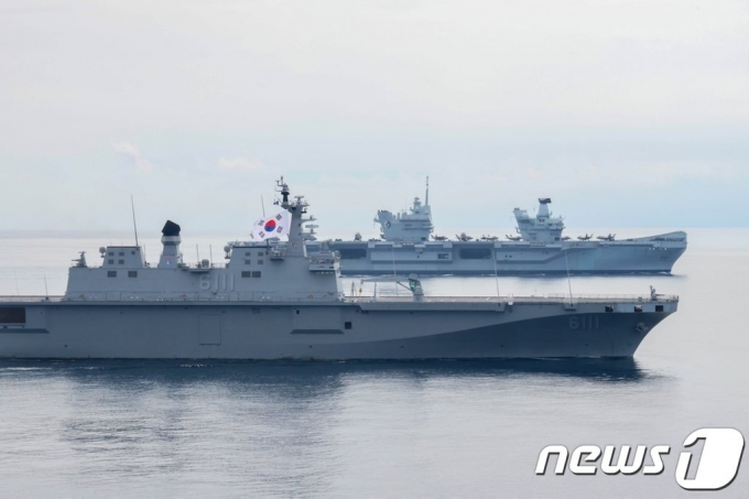 우리 해군 강습상륙함 '독도함'(앞)과 영국 해군 항공모함 '퀸 엘리자베스'가 31일 동해상에서 연합훈련을 했다. '독도함'에 게양돼 있는 태극기가 보인다. (영국 해군 항모전단장 트위터) © 뉴스1