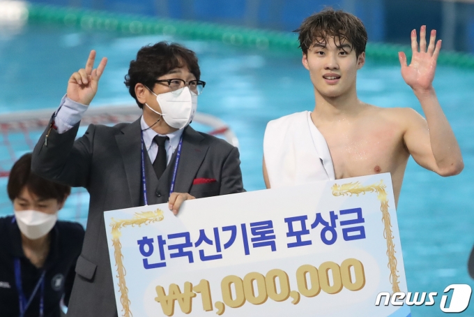 12일 오후 경북 김천실내수영장에서 열린 제102회 전국체육대회 수영 남자 고등부 개인혼영 200m 결승에 출전해 1분58초04의 한국신기록을 세우며 1위를 차지한 황선우(서울체고)가 포상금을 받고 있다. 2021.10.12/뉴스1 © News1 공정식 기자