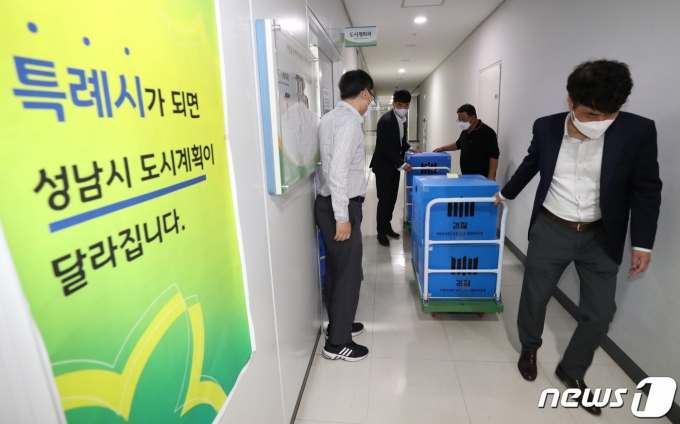 대장동 개발 특혜·로비 의혹을 수사 중인 검찰이 성남시청 압수수색이 끝난 15일 오후 경기도 성남시 중원구 성남시청 도시계획과 사무실에서 검찰 관계자가 압수품을 가지고 나오고 있다. 2021.10.15/뉴스1 © News1 김영운 기자
