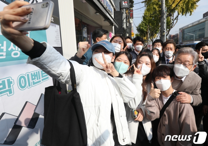 이재명 더불어민주당 대선 후보가 지난 5일 오전 대구 북구 경북대학교 북문 인근에 도착해 학생들의 요청에 기념사진을 찍고 있다. 2021.11.5/뉴스1 © News1 공정식 기자