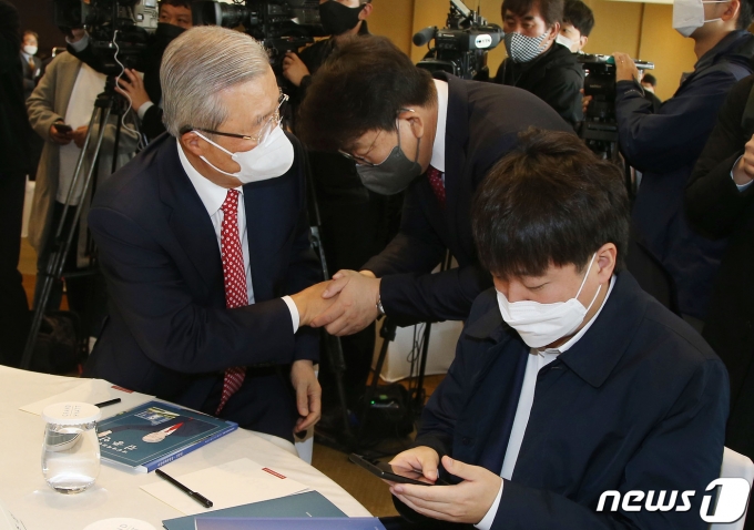 국민의힘 김종인 전 비상대책위원장(왼쪽)과 윤석열 대선 후보의 비서실장인 권성동 의원이 15일 오전 서울 용산구 그랜드 하얏트 서울에서 열린 '만화로 읽는 오늘의 인물이야기 ‘비상대책위원장-김종인' 출판기념회에서 인사를 나누고 있다. 오른쪽은 이준석 대표. 2021.11.15/뉴스1 © News1 국회사진취재단