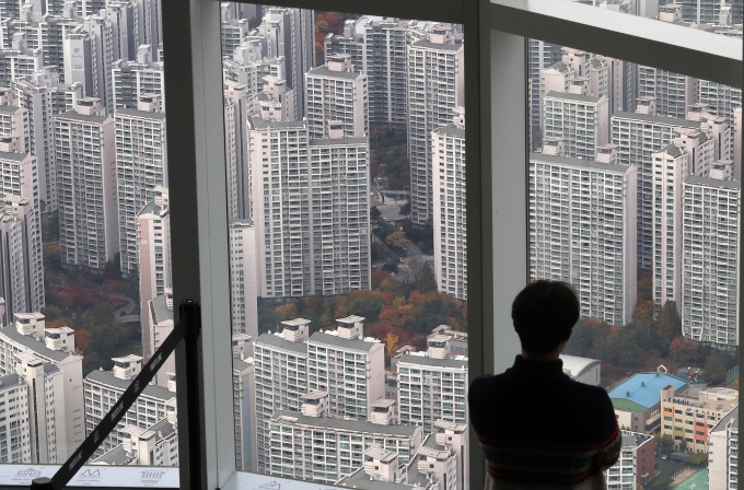 한국은행의 금융통화위원회 회의가 일주일 앞으로 다가온 가운데 신한은행과 하나은행의 변동형 주택담보대출 금리가 이틀만에 최대 0.17%포인트 오른 것으로 나타났다. 사진은 서울 송파구 롯데월드타워에서 아파트를 바라보는 시민의 모습./사진=뉴스1