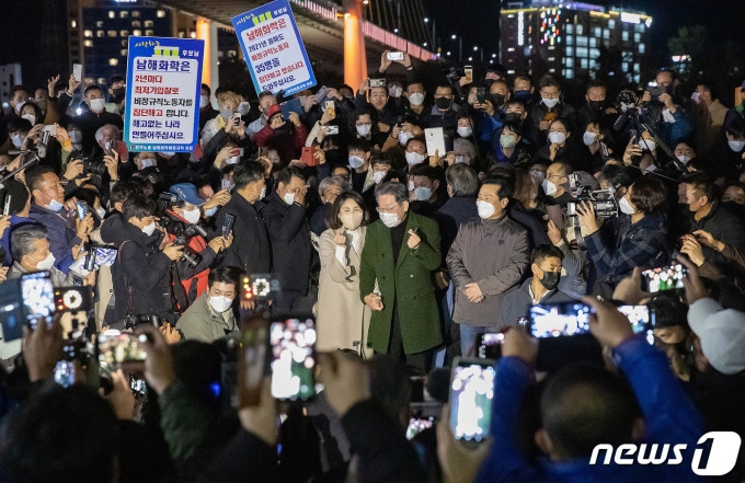 이재명 더불어민주당 대선 후보와 배우자 김혜경 씨가 27일 전남 여수의 명소인 낭만포차에서 시민들과 기념사진을 찍고 있다. 2021.11.27/뉴스1 © News1 이동해 기자