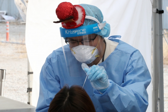 국내 신종 코로나바이러스 감염증(코로나19) 위중증 환자가 처음으로 1000명을 넘어선 것으로 확인됐다. 사진은 서울 강서구 마곡8구역 공영주차장 임시선별검사소에서 의료진이 크리스마스 모자를 쓰고 검체를 채취하고 있는 모습. /사진제공=뉴시스