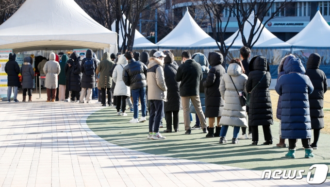 서울 영하 10도로 올겨울 들어 가장 추운 날씨를 기록한 18일 오전 서울광장에 마련된 코로나19 중구 임시선별검사소에서 시민들이 줄 서 있다. 2021.12.18/뉴스1 © News1 안은나 기자
