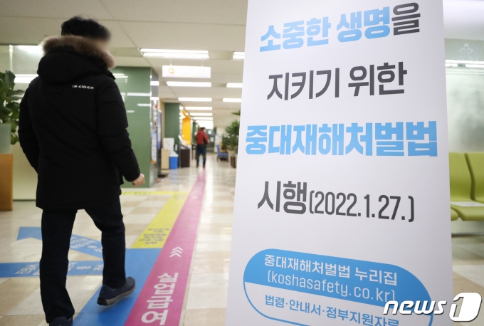 중대재해처벌법 시행을 하루 앞둔 26일 서울 중구 서울고용복지플러스센터에 중대재해처벌법 안내문이 세워져 있다. 정부는 27일 50인 이상 기업에 중대재해법을 적용한다. 중대재해법은 사업 또는 사업장, 공중이용시설 및 공중교통수단을 운영하거나 인체에 해로운 원료 제조물 취급 시 안전·보건 조치의무를 위반해 인명피해를 발생하게 한 사업주, 경영책임자, 공무원 및 법인에 대한 처벌 등을 규정한 법이다. 2022.1.26/뉴스1 © News1 허경 기자