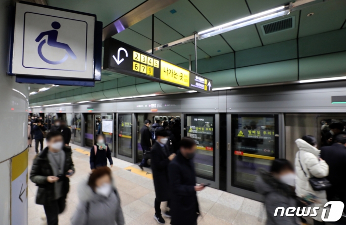 20일 오전 서울 종로구 지하철 5호선 광화문역에서 출근길 시민들이 전국장애인차별철폐연대 회원들의 이동권 보장 촉구 시위에 불편을 겪고 있다. 2021.12.20/뉴스1 © News1 이재명 기자