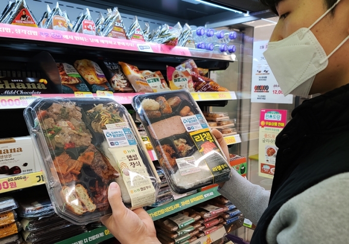 편의점 CU가 도시락 구매 시 밀크코인을 증정하는 이벤트를 진행한다. 사진은 고객이 도시락 상품을 살펴보고 있다./사진제공=BGF리테일