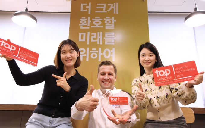 오비맥주 배하준 대표(가운데)가 ‘최고 고용주 협회’가 수여하는 ‘2022 최우수 고용기업’ 상을 받고 직원들과 함께 기념사진을 찍고 있다. (오비맥주 제공)