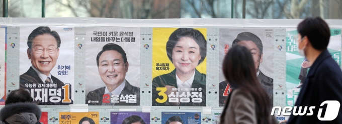 제20대 대통령 선거 사전투표를 하루 앞둔 3일 오후 서울 종각옆 앞에서 유권자들이 후보들의 선거벽보를 지켜보고 있다. 윤석열 국민의힘 대선 후보와 안철수 국민의당 대선 후보는 이날 오전 