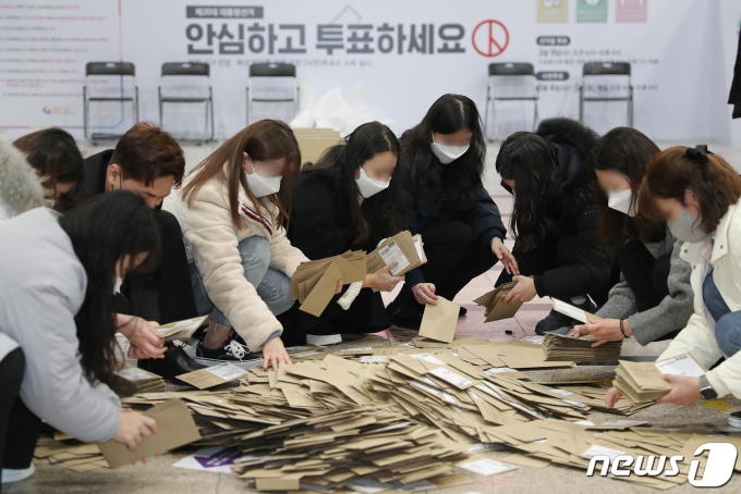 제20대 대통령 선거 사전투표가 끝난 5일 오후 서울역 설치된 남영동 사전투표소에서 관계자들이 투표함을 열어 관외 투표용지 봉투를 확인하고 있다. 2022.3.5/뉴스1 © News1 김진환 기자