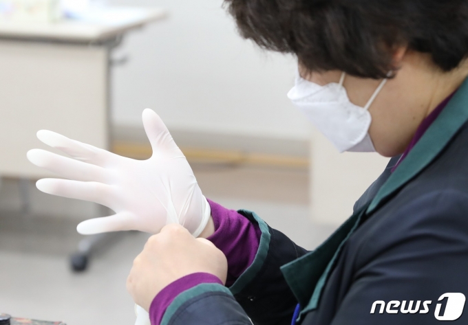 제21대 국회의원선거 투표일인 15일 오전 서울 중구 명동주민센터에 마련된 명동제1투표소에서 선거참관인이 신종 코로나바이러스 감염증(코로나19) 예방을 위해 라텍스 장갑을 끼고 있다. 2020.4.15/뉴스1 © News1 정지형 기자