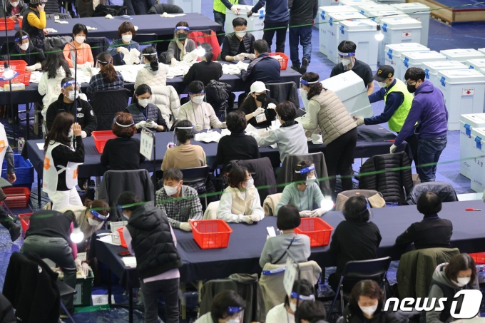제20대 대통령 선거 투표가 끝난 9일 오후 개표소인 서울 영등포 다목적 배드민턴체육관에서 개표원들이 투표함을 개봉하고 있다. 2022.3.9/뉴스1 © News1 안은나 기자