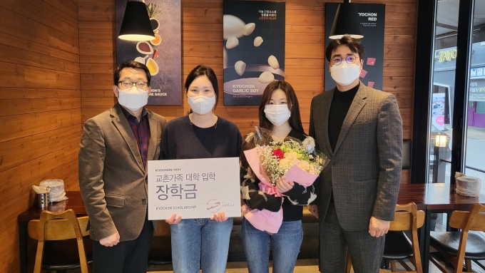교촌에프앤비(주) 관계자가 장학금 수혜 가맹점주 가족과 기념촬영을 하고 있다.(교촌치킨 제공)