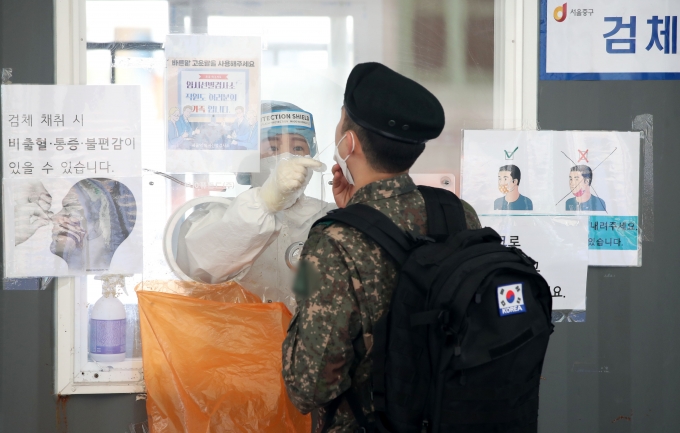 전국 군부대에서 신종 코로나바이러스 감염증(코로나19) 누적 확진자가 7만명 선을 넘어섰다. 서울역 광장에 마련된 중구 임시선별검사소에서 의료진이 군인의 검체를 채취하고 있다. /사진=뉴시스