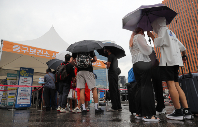 신종 코로나바이러스 감염증(코로나19) 일일 신규 확진자가 지난 24일에 비해 1만명 가량 감소했다. 사진은 지난 25일 비가 오는 날씨에도 서울 중구 서울역 임시선별검사소에서 검사를 받기 위해 대기하는 시민. /사진=뉴시스