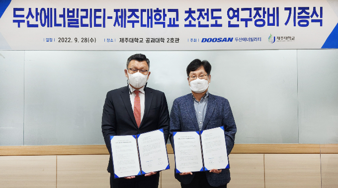 지난  28일 제주대학교에서 열린 ‘두산에너빌리티-제주대학교 초전도 연구장비 기증식’에 참석한 임종환 제주대 교수(오른쪽)와 송용진 두산에너빌리티 부사장(왼쪽)이 서명 후 기념촬영을 하고 있다. /사진=두산에너빌리티