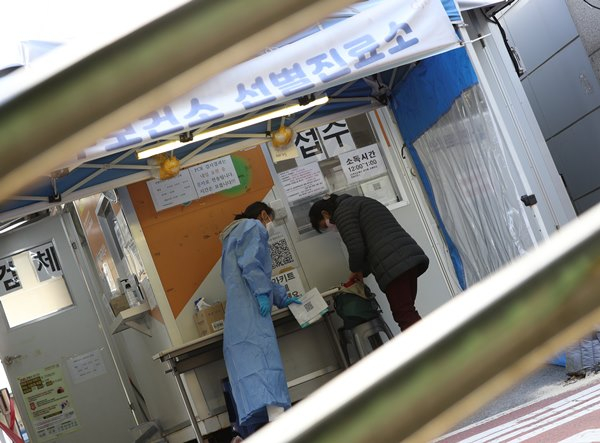 신종 코로나바이러스 감염증(코로나19) 신규 확진자가 28일 0시 기준 3만5924명으로 사망자는 31명으로 집계됐다. 사진은 지난 26일 서울 구로구보건소에 마련된 코로나19 선별진료소에서 코로나19 검사를 받기 위해 온 시민(오른쪽)을 문진하는 의료진. /사진=뉴스1 