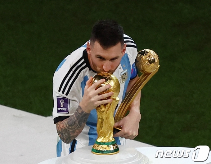 18일(현지시간) 카타르 루사일 스타디움에서 열린 2022 국제축구연맹(FIFA) 카타르 월드컵 결승전, 프랑스를 상대로 승리해 우승을 차지한 아르헨티나의 리오넬 메시가 최우수 선수상인 골든볼을 수상한 뒤 월드컵 트로피에 입맞추고 있다. 이날 아르헨티나는 승부차기 끝에 승리하며 36년 만의 월드컵 우승을 이뤘다. 2022.12.19 ⓒ 로이터=뉴스1