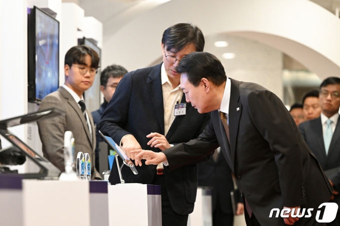 윤석열 대통령이 2일 용산 대통령실 청사에서 열린 CES(국제전자제품박람회) 2023 디지털 기술혁신 기업 CEO들과의 오찬 간담회에 앞서 CES 최고혁신상을 수상한 지크립토 오현옥 대표에게 블록체인 기반 온라인 투표앱에 대한 설명을 듣고 있다. (대통령실 제공) 2023.2.2/뉴스1 ⓒ News1 오대일 기자
