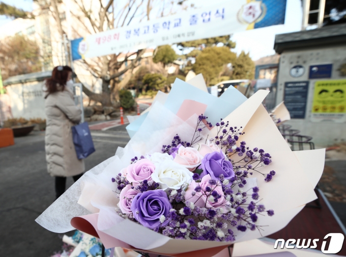 3일 오전 제98회 졸업식이 열린 서울 종로구 경복고등학교 앞에서 한 상인이 꽃다발을 팔고 있다. 졸업식과 입학식 시즌을 앞두고 실내 마스크 해제로 대목을 기대했던 꽃집과 화훼 농가들은 신종 코로나바이러스 감염증(코로나19) 여파로 화훼 농사를 접은 농가의 증가와 등유 가격 상승으로 난방비가 치솟으며 생화 가격이 올라 어려움을 겪고 있다. 2023.2.3/뉴스1 ⓒ News1 김민지 기자
