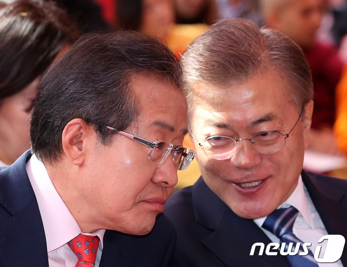 2017년 5월 3일 부처님오신날을 맞아 서울 종로구 조계사에서 열린 봉축 법요식에 참석한 당시 문재인 더불어민주당 대선후보와 홍준표 자유한국당 대선후보가 대화를 나누고 있다. ⓒ 뉴스1 DB