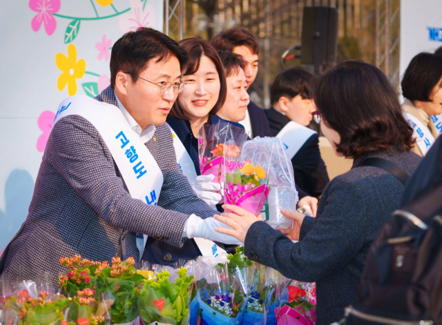 이석용 NH농협은행장(왼쪽)이 출근길 시민에게 미니화분을 주며 인사를 나누고 있다. /사진 제공=NH농협은행
