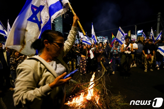 1일(현지시간) 이스라엘 수도 텔아비브에서 국기를 든 시민들이 베냐민 네타냐후 총리가 추진하는 사법 개편안을 즉각 폐기할 것을 촉구하고 있다. 2023.04.01. ⓒ 로이터=뉴스1 ⓒ News1 김성식 기자