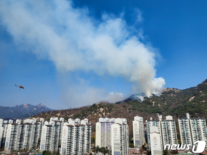 2일 서울 종로구 인왕산에서 산불이 발생해 산림청 헬기가 진화작업을 하고 있다. 소방당국은 2일 인왕산 산불과 관련, 대응 2단계를 발령하고 헬기 11대를 동원해 산불 진화작업을 벌이고 있으며, 진화율은 현재 70~80% 정도라고 밝혔다. 2023.4.2/뉴스1 ⓒ News1 유승관 기자