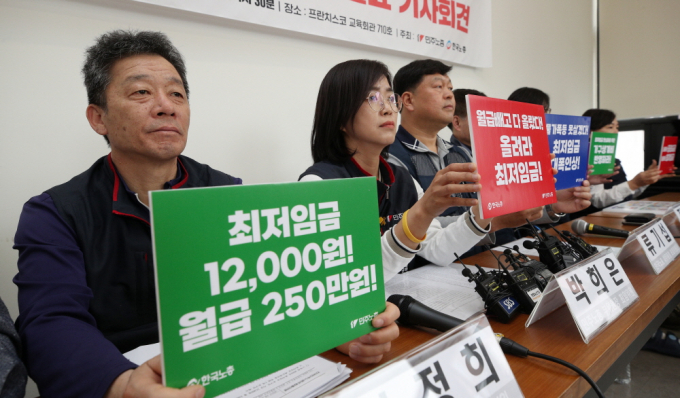 양대노총 관계자들이 4일 서울 중구 프란치스코회관에서 열린 '2024년 적용 최저임금 노동계 요구안 발표 기자회견'에서 최저임금 인상을 촉구하는 손팻말을 들고 있다. 