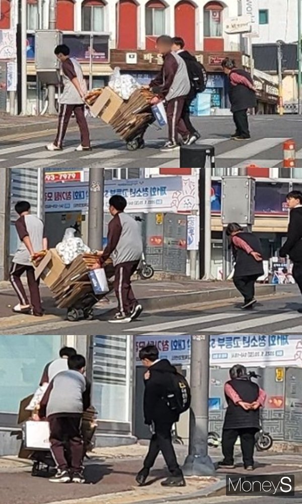 10대 학생들이 폐지 줍는 어르신을 돕기 위해 횡단보도에서 손수레를 끄는 모습이 포착돼 훈훈함을 안겼다. 사진은 충남 아산시 한 사거리에서 할머니를 돕기 위해 대신 손수레를 미는 학생들. /사진=온라인 커뮤니티 보배드림 캡처