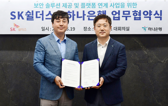 하나은행은 라이프 케어 플랫폼 기업 SK쉴더스와 지난 19일 서울 강남구 삼성동 소재 SK쉴더스 사옥에서 '보안솔루션 제공 및 금융서비스와 연계한 공동 비즈니스 추진'을 위한 업무협약을 체결했다.  협약식에 참석한 이동현 하나은행 기업사업본부장(오른쪽)과 김윤호 SK쉴더스 성장추진실장(왼쪽)이 기념촬영을 하고 있다./사진=하나은행