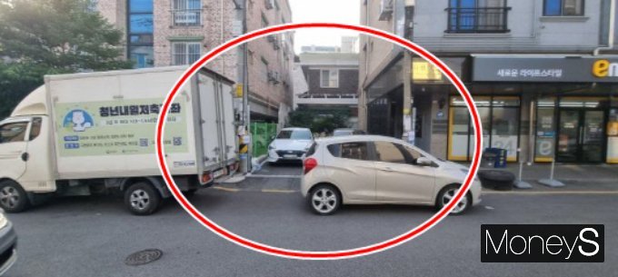 주차장 입구를 막은 차주 때문에 아침 출근시간 곤욕을 치렀다는 누리꾼의 하소연이 전해졌다. 사진은 건물 외부 주차장의 진입로를 절반 정도 막은 채 서있는 소형차. /사진=온라인 커뮤니티
