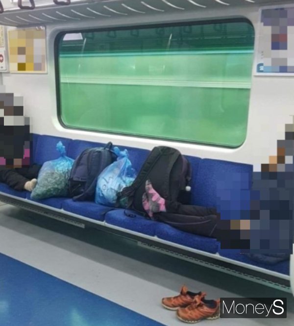 지하철 좌석에 자신들 짐·발을 올린 민폐 탑승객이 누리꾼의 공분을 사고 있다. 사진은 지하철 7인석을 점령한 승객 2명의 모습. /사진=온라인 커뮤니티