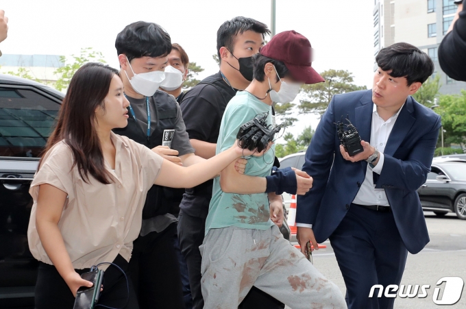 14살 연상 동거녀를 살해한 혐의를 받는 피의자 30대 남성 A씨가 26일 서울 금천구 금천경찰서로 압송되고 있다. A씨는 이날 오전 7시17분쯤 서울 금천구 시흥동의 한 상가 지하주차장에서 동거인 B씨(47·여)에게 흉기를 휘두른 뒤 차에 태우고 도주한 혐의를 받는다. 2023.5.26/뉴스1 ⓒ News1 김성진 기자