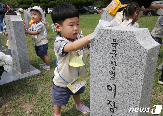 현충일을 하루 앞둔 5일 대전 유성구 국립대전현충원 1묘역에서 어린이집 원생들이 묘비를 닦고 있다./뉴스1 ⓒ News1 김기태 기자