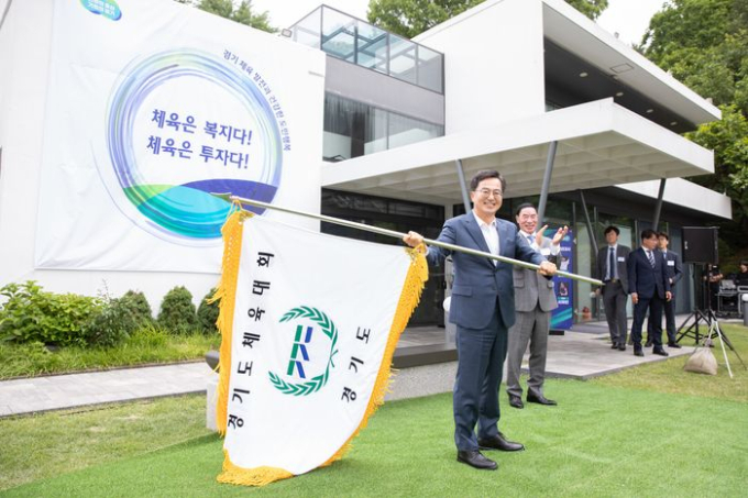8일 수원 도담소에서 열린 ‘경기체육?발전?소통?간담회’에서 김동연 도지사가 경기도체육대회기를 이원성 경기도체육회장에게 이양하기에 앞서 흔들어 보이고 있다. / 사진제공=경기도