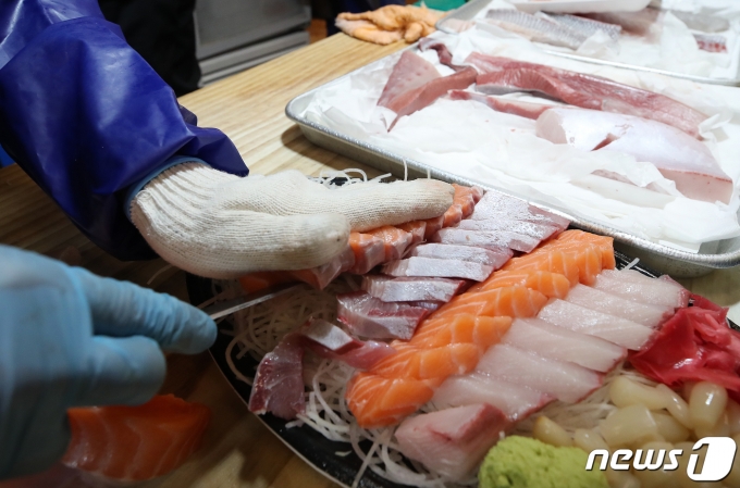 서울 동작구 노량진 수산시장 내 활어매장에서 연어회를 뜨는 모습. 2021.12.29/뉴스1 ⓒ News1 김진환 기자