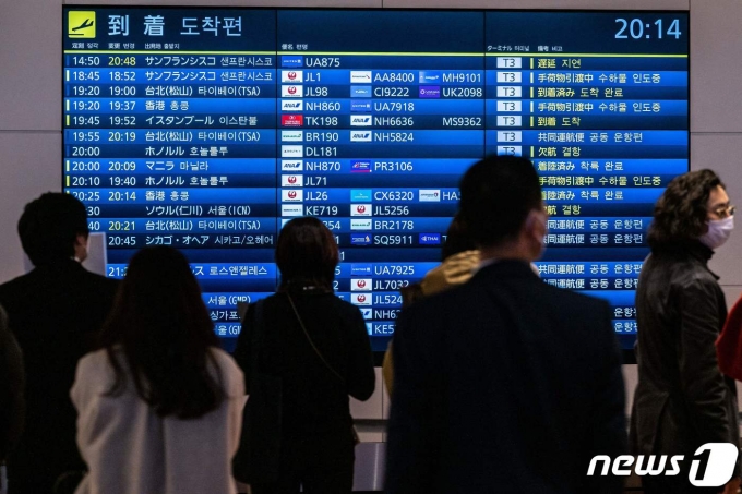 28일(현지시간) 도쿄 하네다 국제 공항에서 시민들이 국제선의 도착을 알리는 전광판 앞에서 기다리고 있다. ⓒ AFP=뉴스1 ⓒ News1 우동명 기자