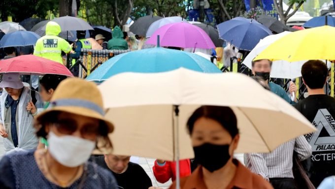 목요일인 오는 15일 전국적으로 구름이 많고 대부분 지역에 소나기가 내릴 것으로 예보됐다. 사진은 지난 8일 서울 중구 세종대로에서 우산을 쓴 시민들의 모습. /사진=뉴스1