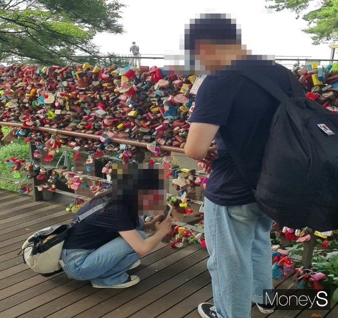 환경보건시민센터가 녹슨 자물쇠는 일종의 시각 공해로 토양오염과는 거리가 있다고 밝혔다. 사진은 지난 26일 서울 중구 남산에서 자물쇠를 걸고 인증 사진을 찍는 연인. /사진=정원기 기자