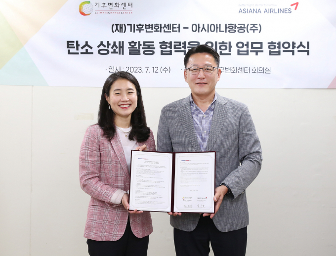아시아나항공이 국내 항공사 최초로 기후변화센터와 ‘자발적 탄소 상쇄 프로그램’ 제공을 위한 업무협약(MOU)을 맺었다. 사진은 서울 종로구 기후변화센터 본사에서 열린 협약식에 참석한 김소희(왼쪽) 기후변화센터 사무총장과 박수상 아시아나항공 상무. /사진=아시아나항공