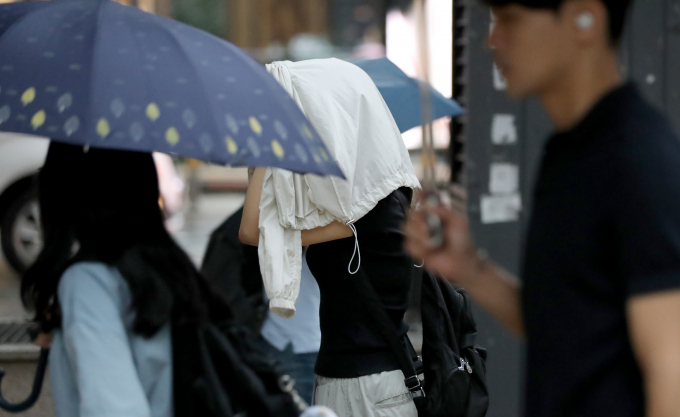 화요일 25일에는 전국에 장맛비가 내리고 늦은 오후 남부 지방부터 비가 점차 그칠 전밍이다. 사진은 지난 11일 오전 서울 종로구에서 우산을 준비 못한 시민이 갑자기 쏟아지는 비를 외투로 막고 있는 모습. /사진=뉴스1
