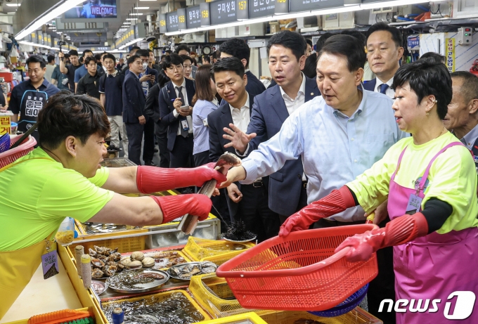 윤석열 대통령이 27일 부산 중구 자갈치시장을 찾아 수산물 시장 상황을 점검하며 장어를 들어보이고 있다. 2023.7.27/뉴스1 ⓒ News1 부산사진공동취재단