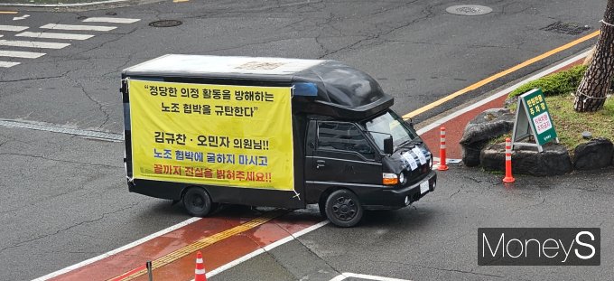 의령군청 앞 도로변에 의령군의회 김규찬 의장과 오민자 의원을 응원하는 문구가 적힌 정체불명의 차량이 주차돼 있다./사진=머니S 독자 제공 