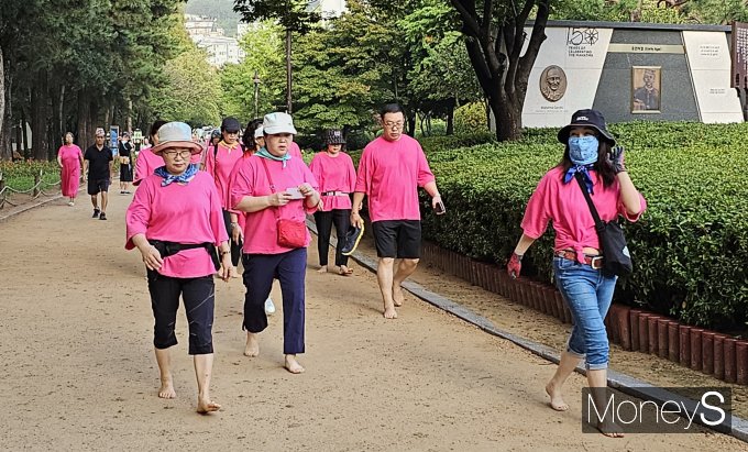 김해시 맨발 걷기 동호회 '어싱포유' 회원들이 지난 16일 연지공원에서 맨발 걷기를 하고 있다./사진=임승제 기자