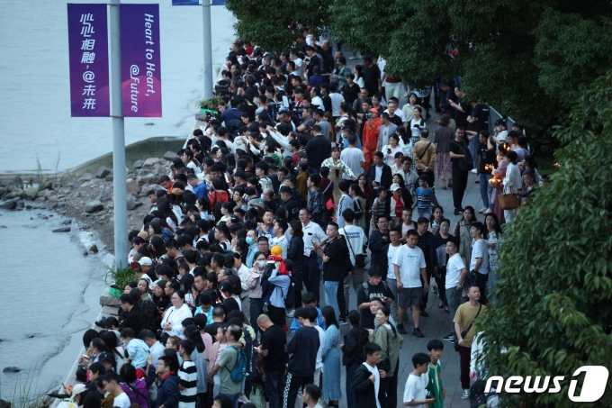 2022 항저우 아시안게임 개막일인 23일 오후 중국 항저우 CBD 공원에서 시민들이 올림픽 스포츠센터 스타디움에 열리는 개막식 라이트 쇼를 기다리고 있다. 아시아 최대의 스포츠축제인 항저우 아시안게임은 항저우의 상징인 연꽃을 건물로 형상화한 항저우의 올림픽 스포츠센터 스타디움에서 열리는 개회식을 시작으로 17일 간 대단원의 막을 올린다. 2023.9.23/뉴스1 ⓒ News1 신웅수 기자