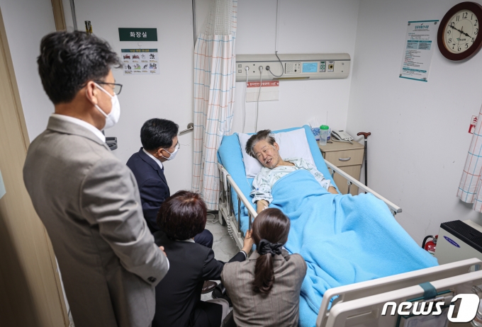 더불어민주당 진성준, 한정애, 강선우 의원과 진교훈 강서구청장 후보가 22일 서울 중랑구 녹색병원을 찾아 단식 중인 이재명 대표의 손을 잡고 대화하고 있다. (더불어민주당 제공) 2023.9.22/뉴스1 ⓒ News1 송원영 기자