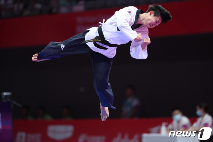 24일 오후 중국 항저우 린안 스포츠문화·전시센터에서 열린 2022 항저우 아시안게임 태권도 품새 남자 개인전 결승에서 강완진이 금메달을 확정 지은 후 기쁨에 날아 오르고 있다. 강완진의 금메달은 대한민국의 항저우 아시안게임 첫 금메달이다. 2023.9.24/뉴스1 ⓒ News1 신웅수 기자