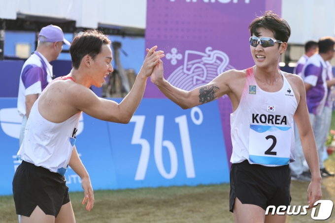 전웅태가 24일 중국 항저우 푸양 인후 스포츠센터에서 열린 근대5종 남자 개인 결선 레이저런에서 1위로 결승선을 통과한 후 2위로 은메달을 차지한 이지훈과 하이파이브를 하고 있다. 2023.9 24/뉴스1 ⓒ News1 유승관 기자